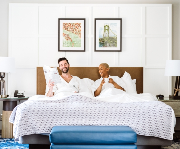 A couple having coffee and reading the paper in bed.