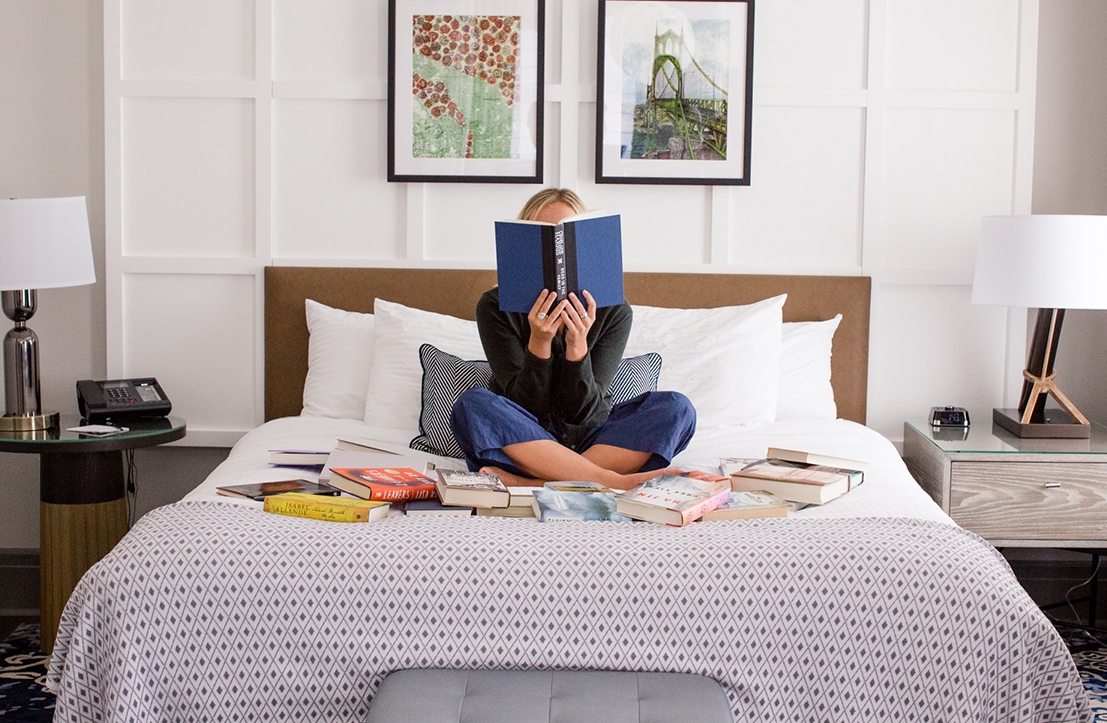 lady setting in the bed while reading