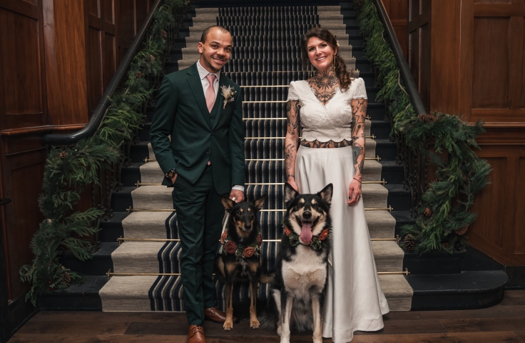 Wedding couple with their dog standing in front of stairs at the Heathman Hotel