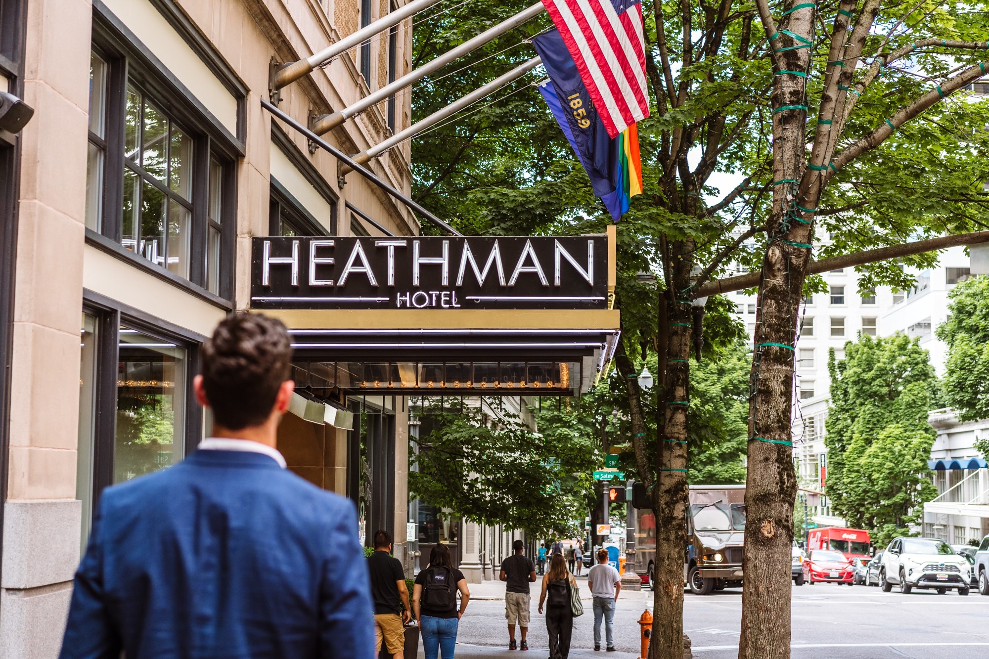 man walking down the street towards Heathman Hotel entrance